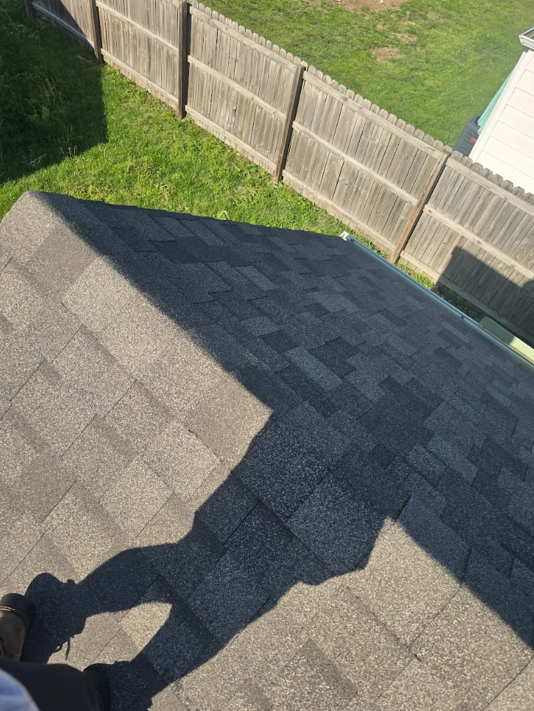 Dark architectural asphalt shingles installed on residential roof with clean edge detail
