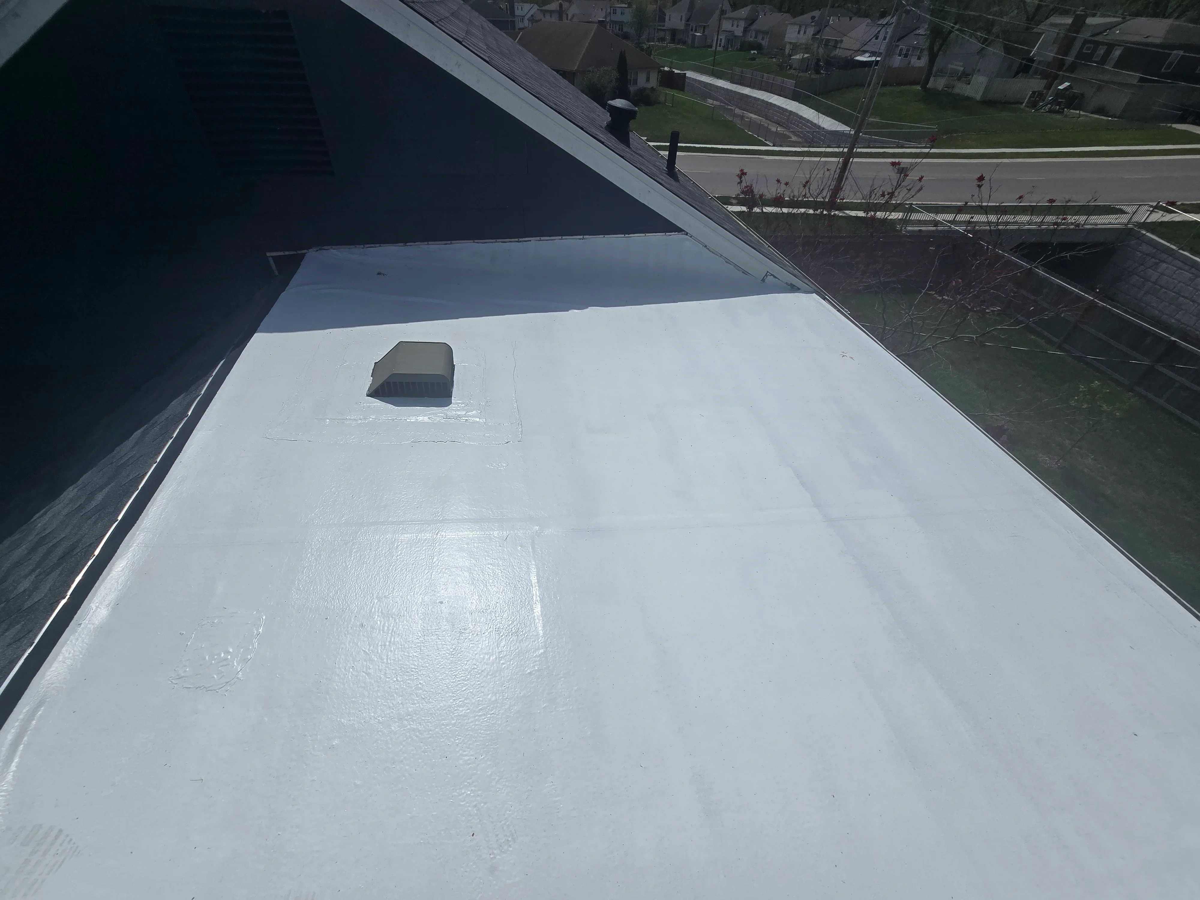 White TPO membrane flat roof with sealed seams and roof vent flashing installation