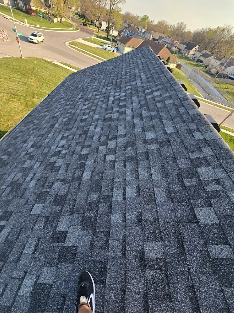 Charcoal gray architectural shingles installed in offset pattern on pitched residential roof