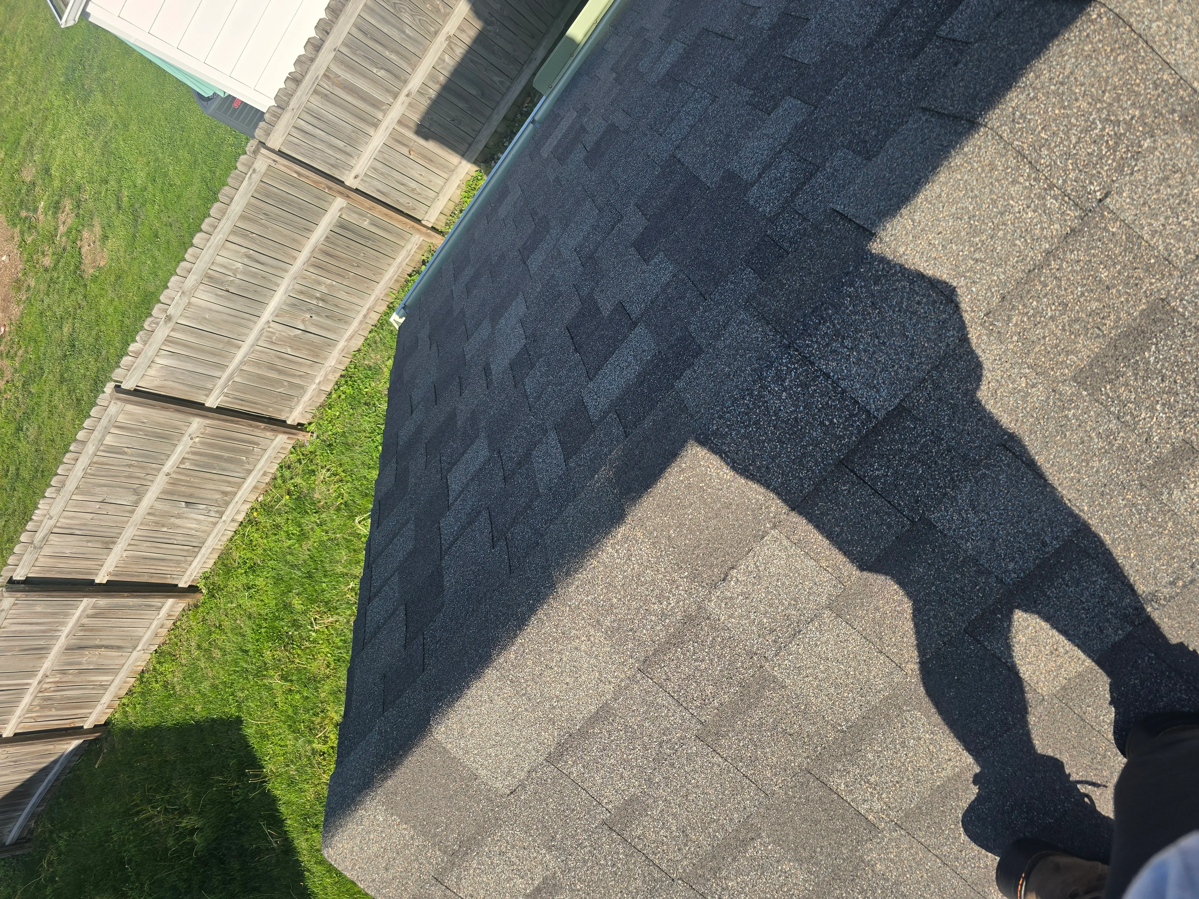Charcoal asphalt shingles installed on roof with staggered pattern and proper overlap