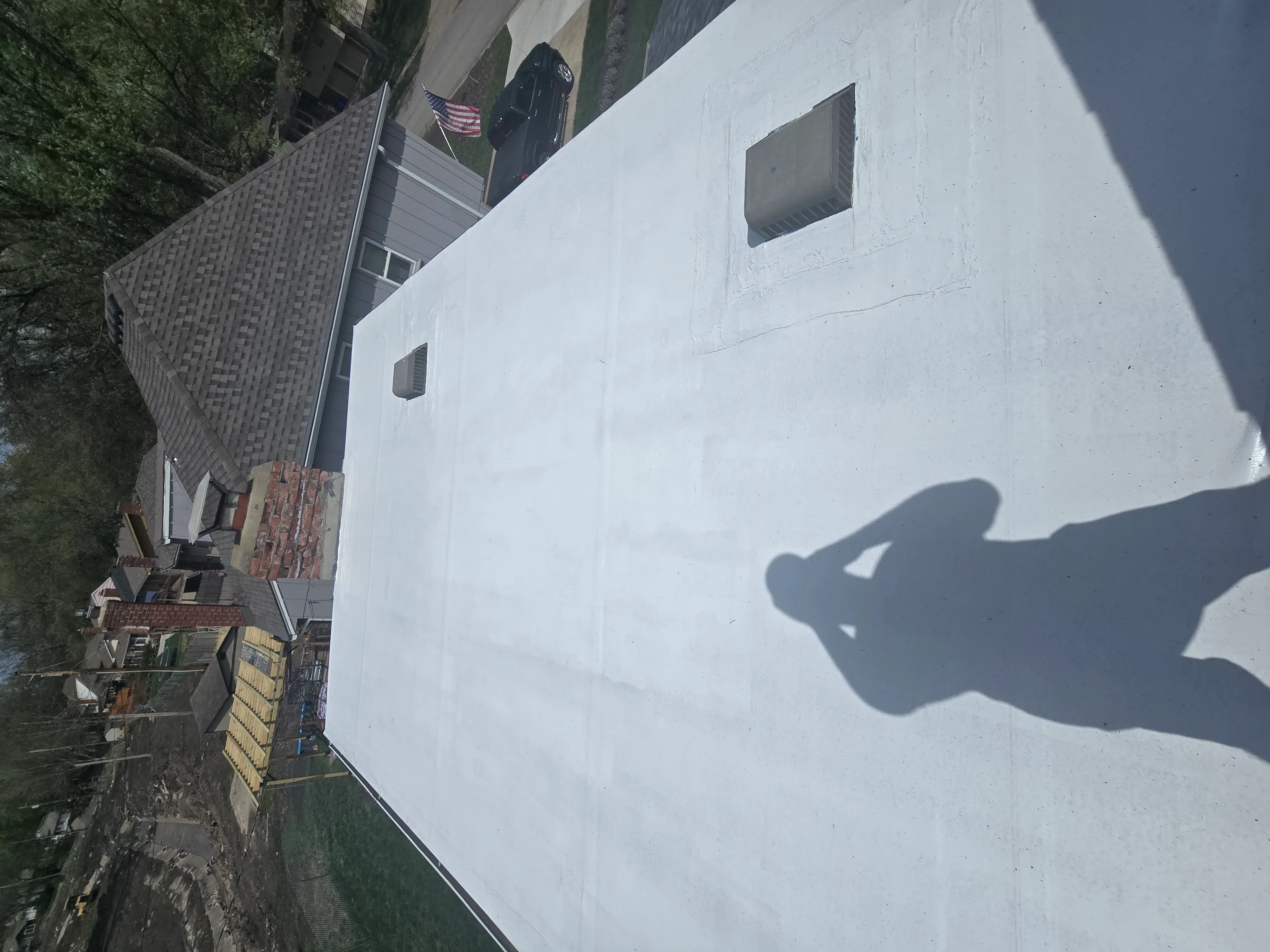 New gray architectural shingles installed on residential roof with proper flashing and ventilation