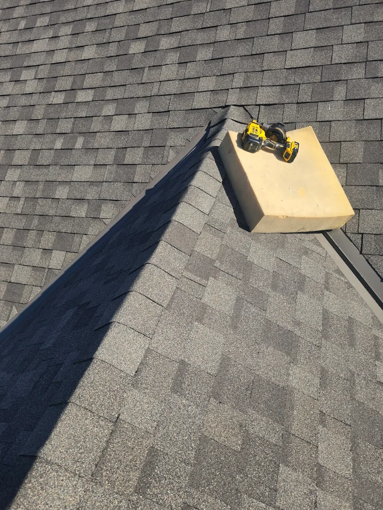 Gray asphalt shingles installed on pitched roof with drip edge and gutter detail