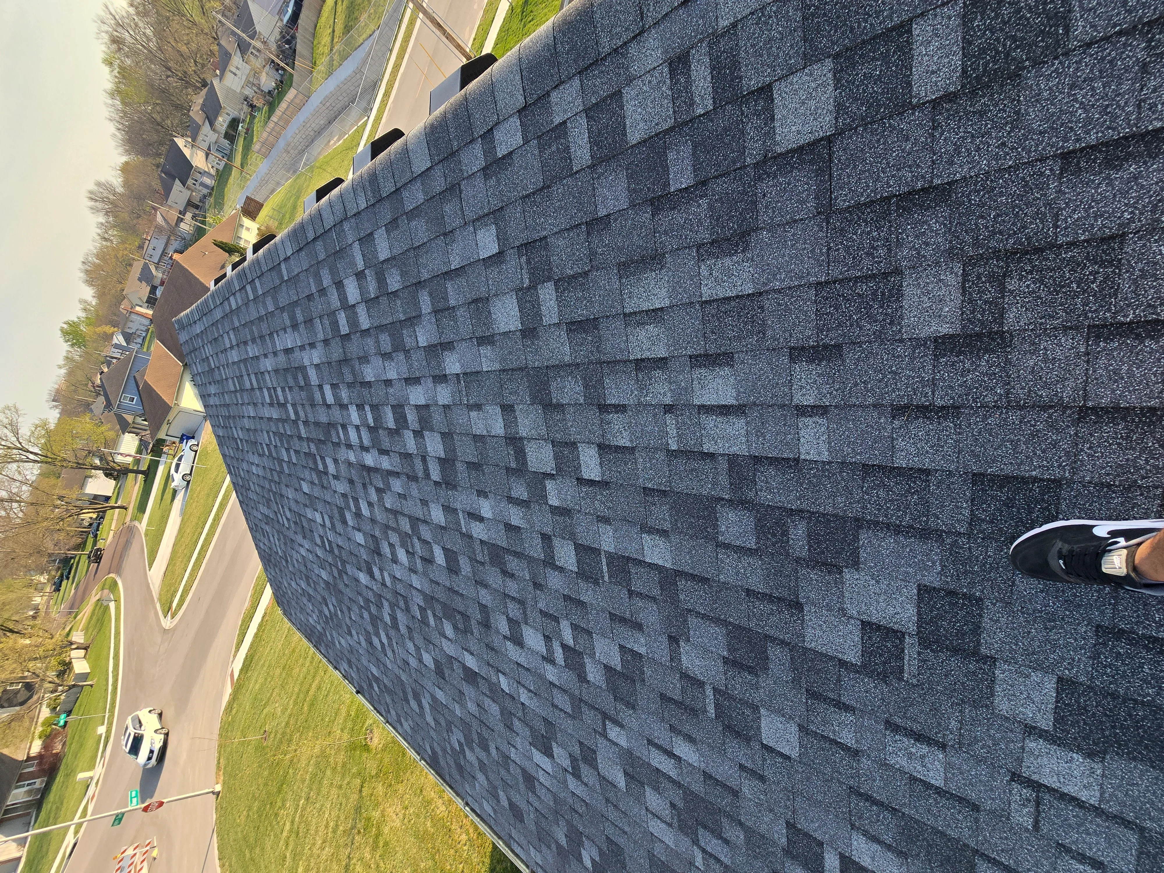 Charcoal gray architectural shingles installed on residential roof with dimensional pattern and proper alignment